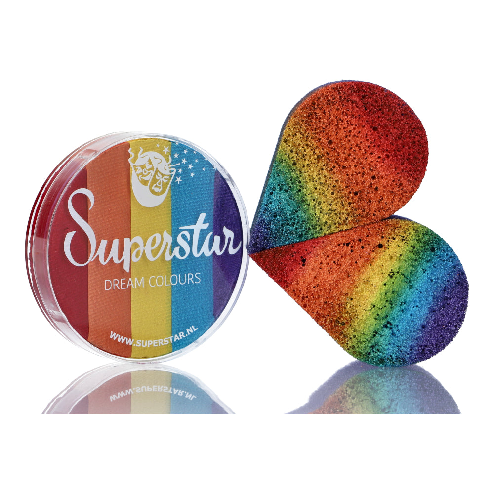 The Split Cake Dream Colour Superstar - Rainbow (45gr) by Infinityfaces, with its circular container and rainbow label, meets the European Cosmetics Directive. It pairs perfectly with a vibrant, heart-shaped rainbow sponge for Aqua Face and Bodypaint lovers.
