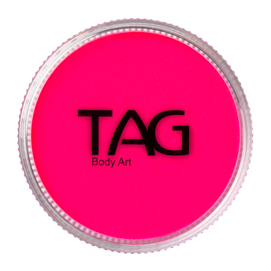 A round Infinity Faces Face Paint & Body Paint Aqua Tag - UV Neon Magenta (32g) is shown from above, featuring a bright neon magenta color. The clear lid displays the black brand logo and product text.