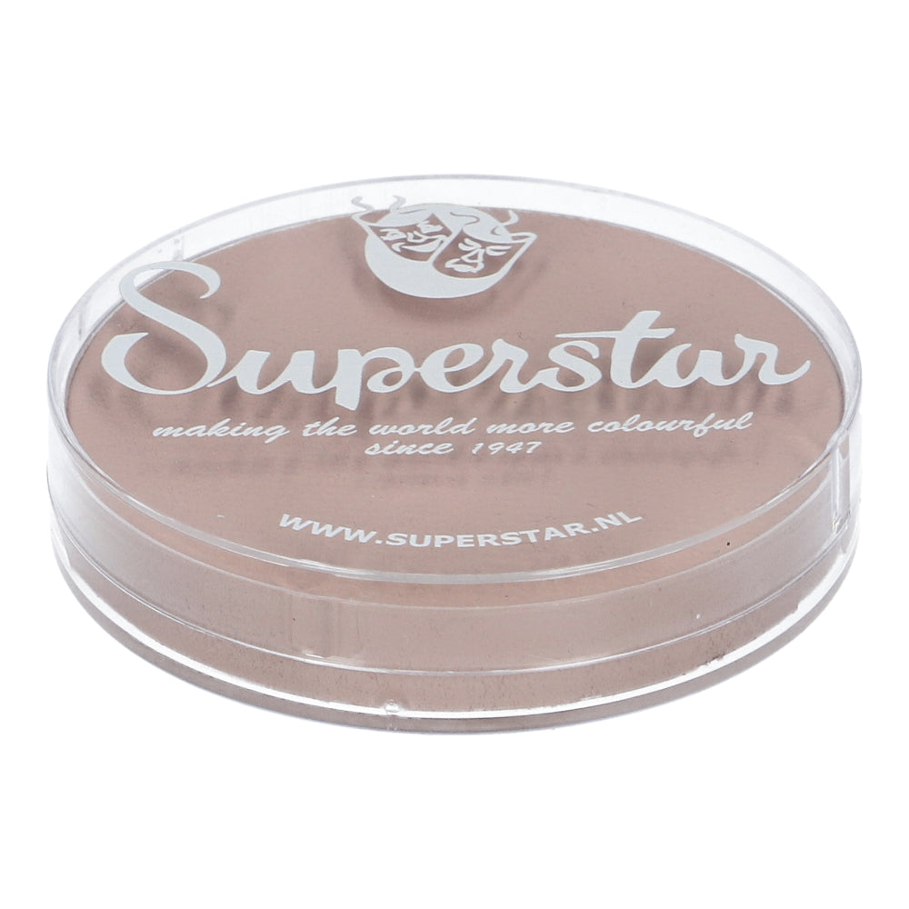 The round, clear container of Face Paint & Body Paint Aqua Superstar - Shock complexion (16gr) from Infinity Faces features a theatrical mask logo and states: making the world more colourful since 1947 and www.superstar.nl. This beige, cruelty-free, water-based makeup is perfect for faces and bodies.