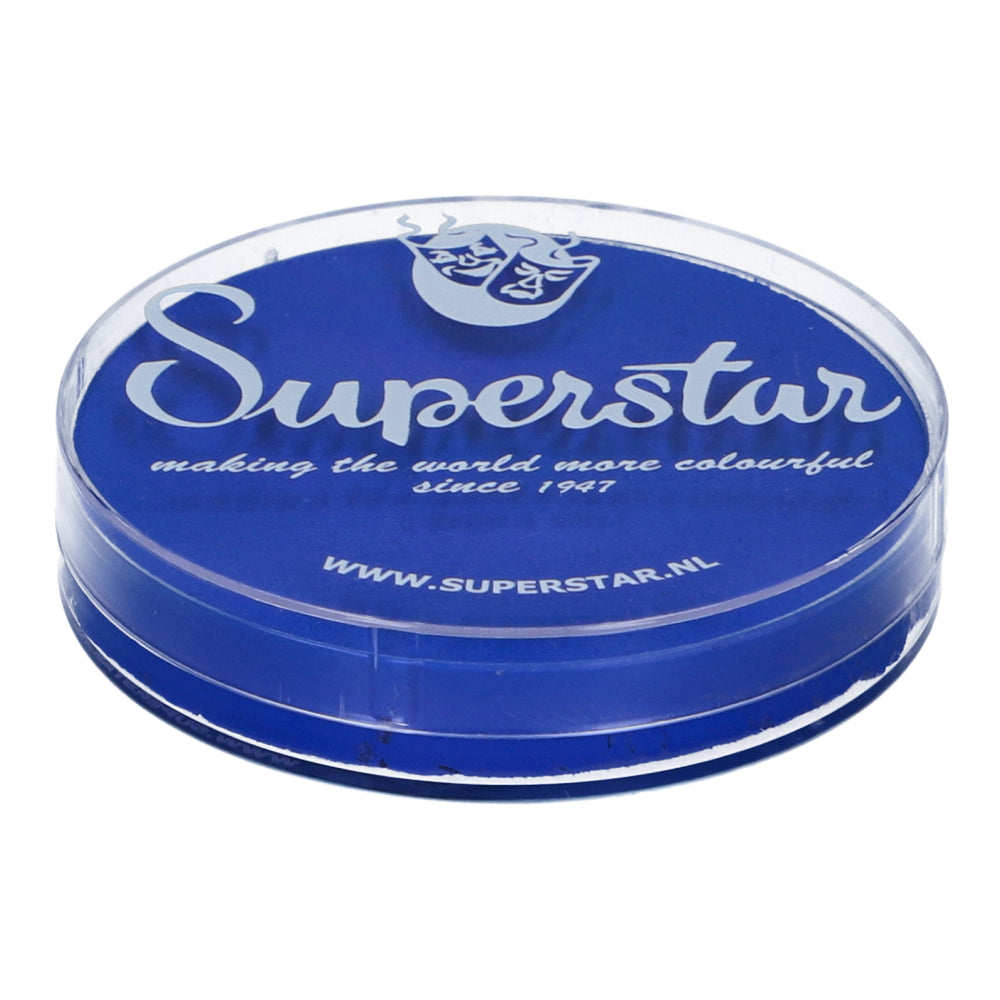 The round container of Infinity Faces Superstar Aqua Face & Body Paint in bright blue features a theater mask logo and the text making the world more colourful since 1947, highlighting www.superstar.nl in white. This 16g water-based makeup is proudly cruelty-free.