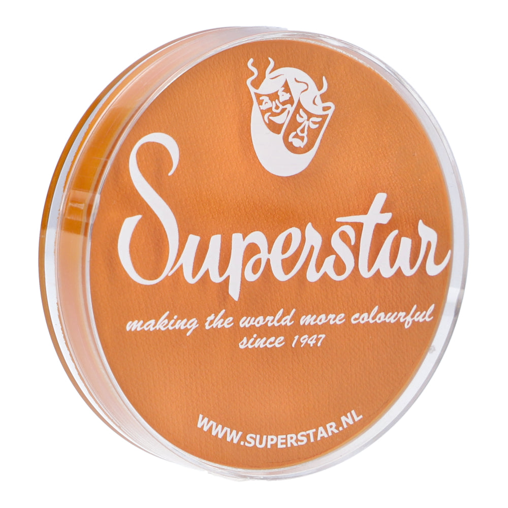 A round container featuring a clear lid and the text Superstar with theater masks carries the slogan, Making the world more colourful since 1947. Highlighting Infinity Faces water-based Face Paint & Body Paint Aqua Superstar in Light Orange (16gr), its compliant with European Cosmetics Legislation. Visit www.superstar.nl for more details.