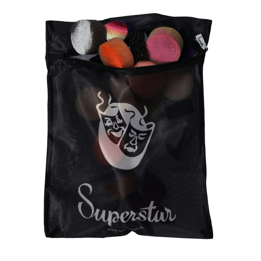 The black mesh Laundry Bag Superstar by Infinity Faces showcases its logo with two theatrical masks and the word Superstar. Through the mesh, you can see colorful makeup sponges in various shapes.