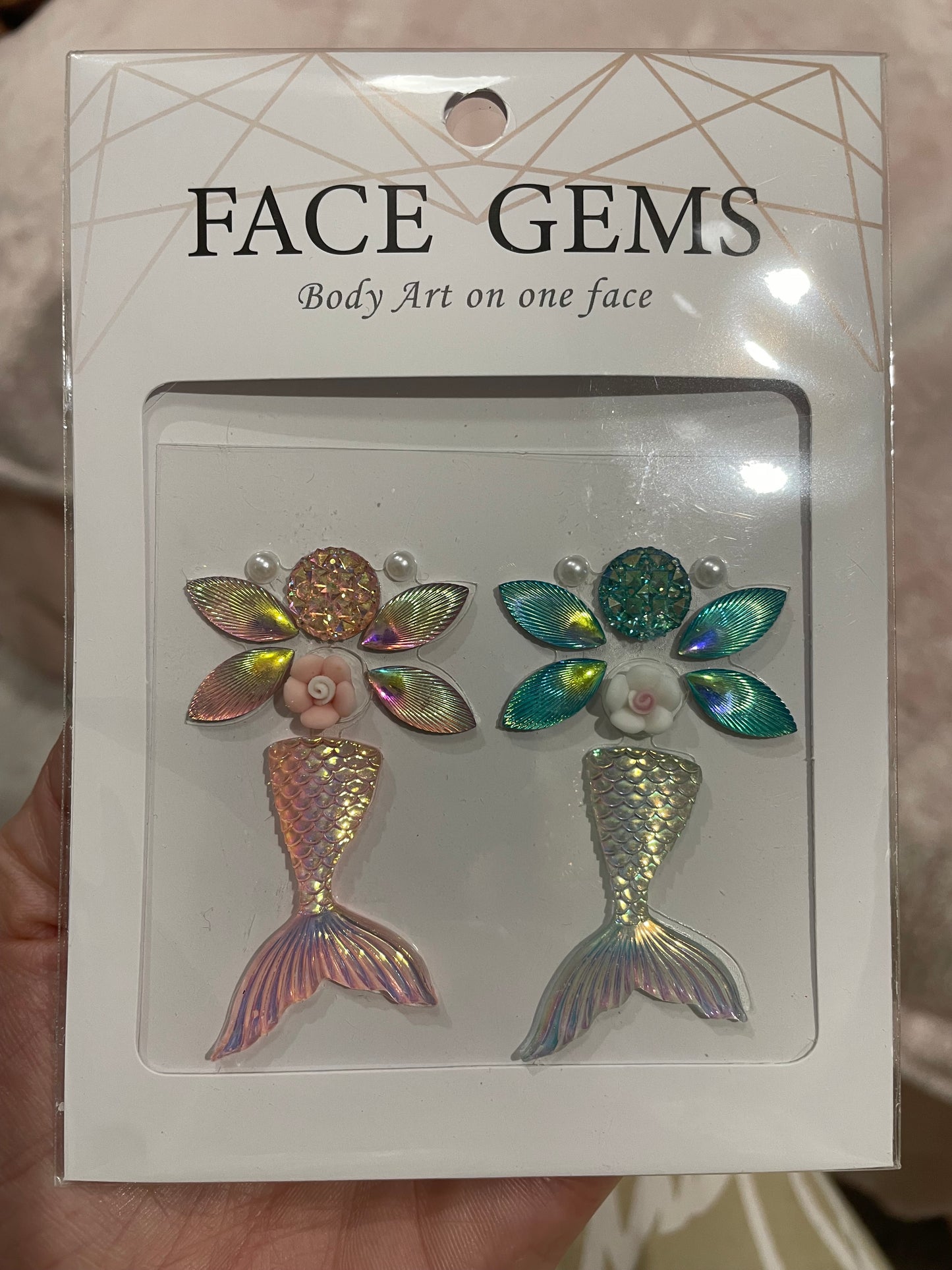 Infinityfaces Face- & Body Gems - Mermaid features mermaid-themed decorations with iridescent tails, flowers, and leaves, along with the text Body Art on one face. Made with reusable adhesive for easy application and removal.