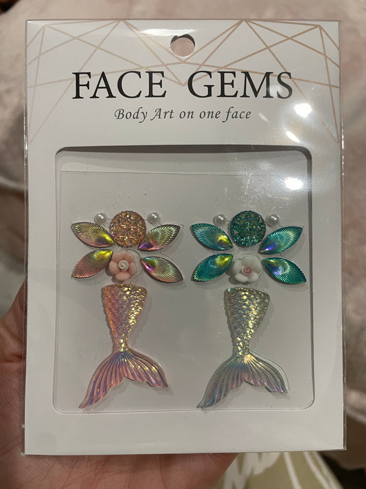 Infinityfaces Face- & Body Gems - Mermaid features mermaid-themed decorations with iridescent tails, flowers, and leaves, along with the text Body Art on one face. Made with reusable adhesive for easy application and removal.