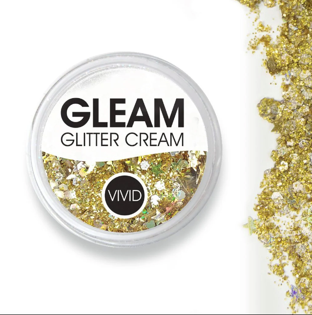A round container labeled Infinity Faces Glitter Cream Gleam - Gold Dust (10g) filled with chunky gold glitter, with some spilled beside it, is shown on a white background.