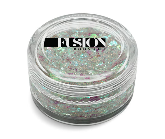 A small clear jar labeled “Infinity Faces” holds 10g of Glitter Cream Fusion - Pixie Kiss UV, featuring iridescent chunky glitter flakes in silver, green, and pink.