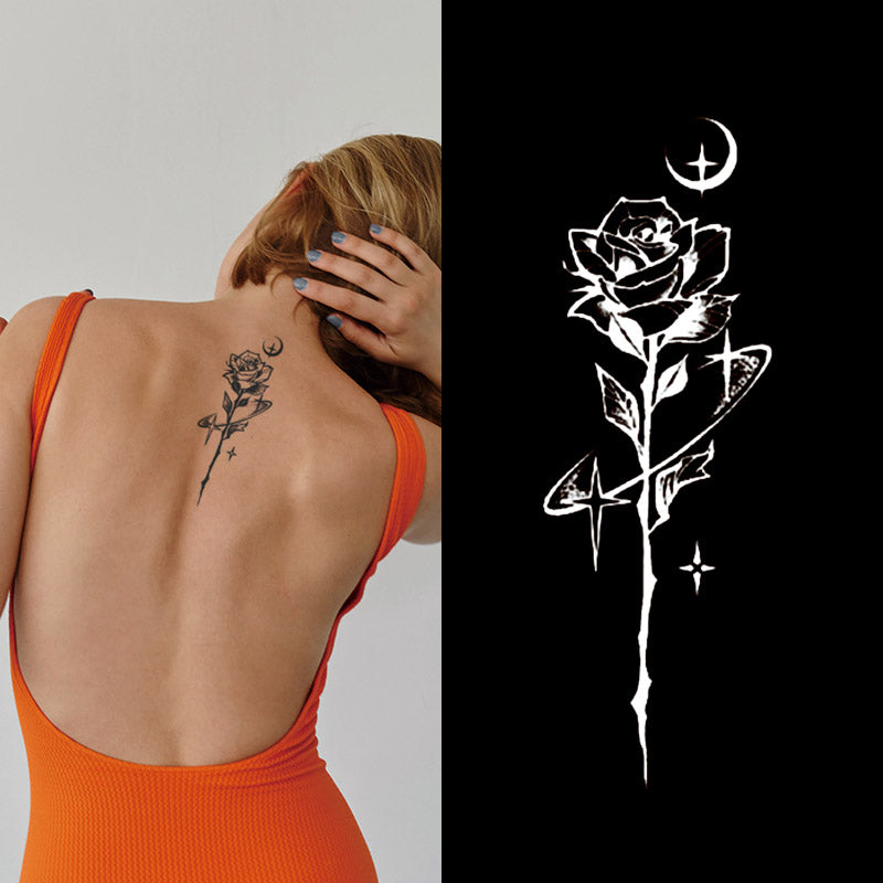 A person in an orange top reveals the Temporary Herbal Tattoo - Rose in a starry night by Infinityfaces, featuring a stylized rose, crescent moon, and stars; beside them, the tattoo is shown in white on a black background.
