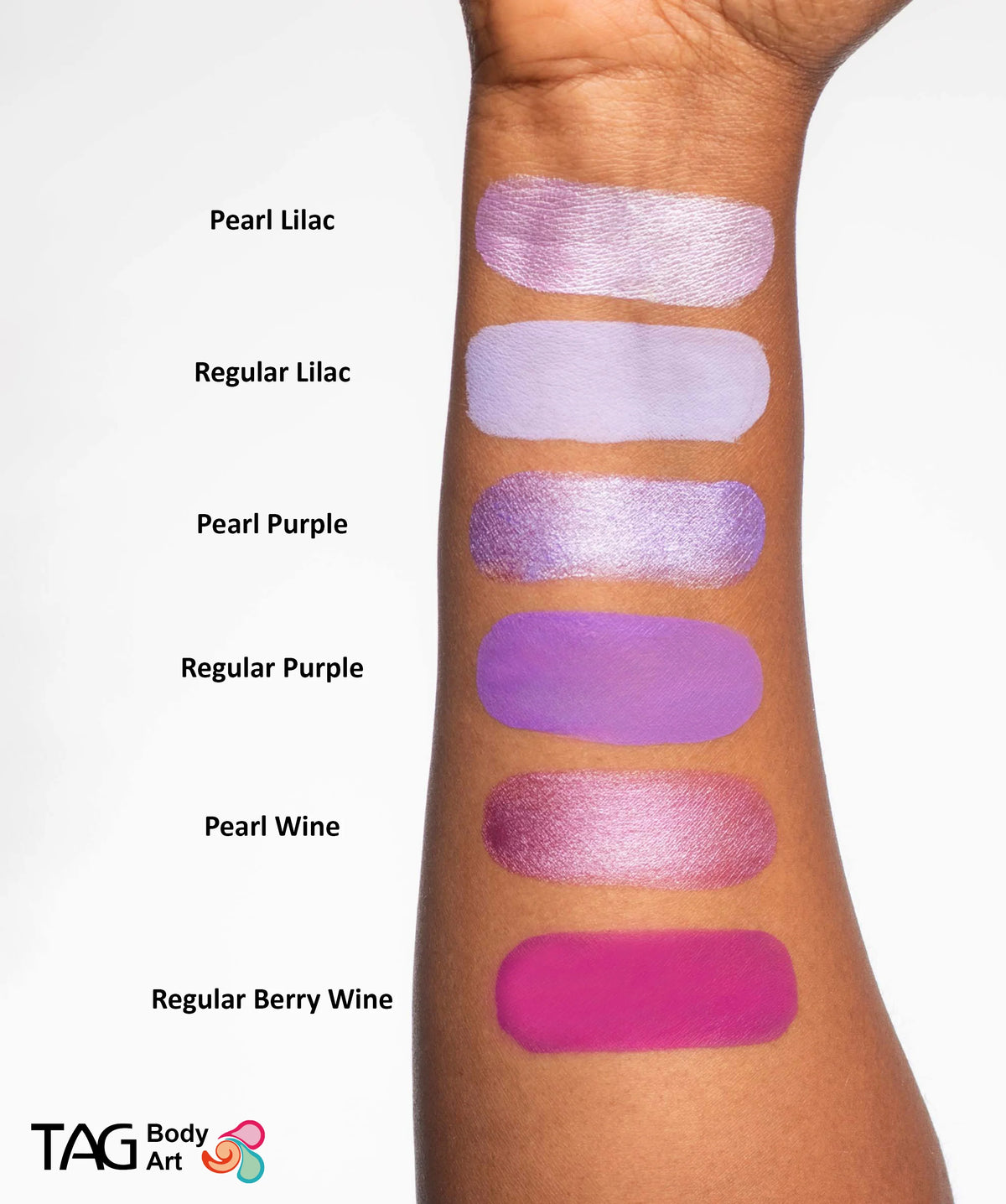 Six shades of TAG Face & Body Paint - Pearl Purple (32g) and regular purple body paint swatched on a forearm, with each color name labeled to the left of the corresponding face paint.