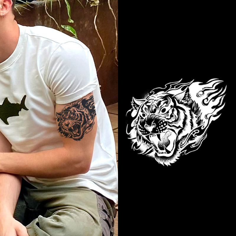 A person in a white t-shirt featuring a black animal silhouette on the sleeve displays their intricate tattoo design. Next to them, Infinityfaces Temporary Herbal Tattoo - Tiger in the Heart mirrors this art with its black and white roaring tiger design, emphasizing the thoughtful tattoo size choice.