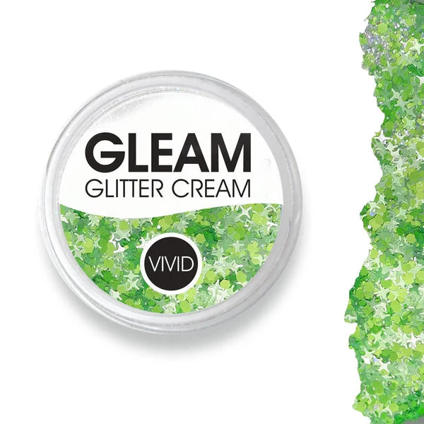 Round container labeled Infinity Faces Glitter Cream Gleam - Honeydew (10g) NEW, filled with green star-shaped glitter; a shimmering green glitter swatch is displayed to the right on a white background.